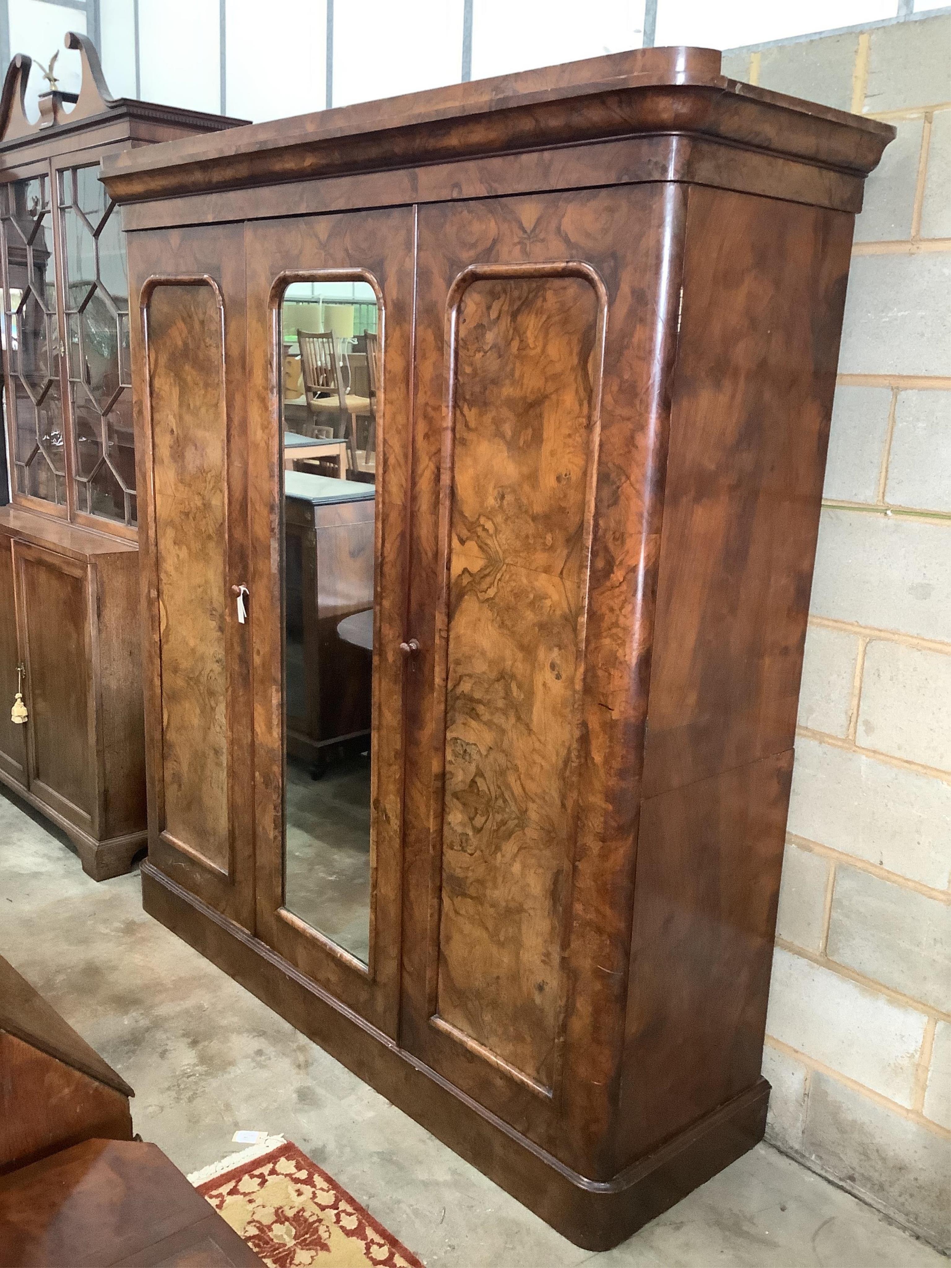 A Victorian figured walnut mirrored compactum wardrobe, width 192cm, depth 49cm, height 208cm. Condition - fair